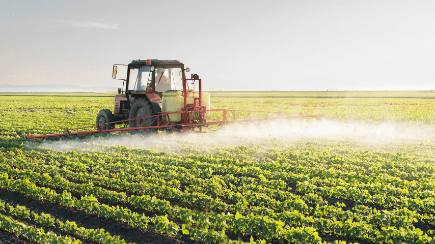 Tractor spraying a field of soybean